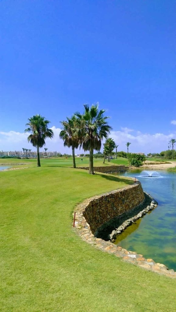 A view of Roda Golf 12th green with water front and back